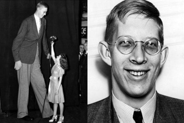 Robert wadlow next to woman and a portrait of him smiling