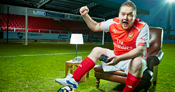 man wearing football kit while holding xbox controller