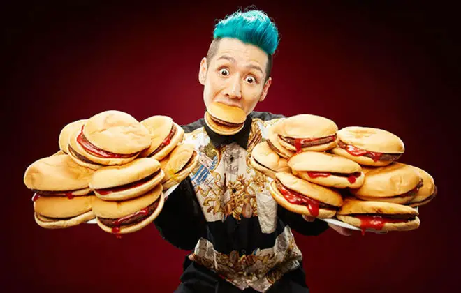 Takeru Kobayashi holding multiple burgers